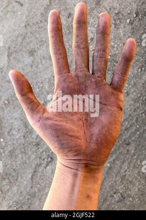 Schmutzige Handfläche der rechten Hand des südostasiatischen Arbeiters. Hautfalten sind offensichtlich. Stockfoto