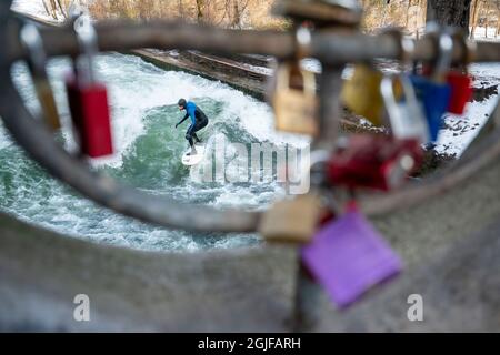 Surfer fahren stromaufwärts im Eisbach in München. Stockfoto