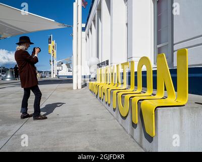 USA, Washington State, Seattle. Frau, die vor dem Museum of History and Industry (MOHai) ein Foto des „Innovation“-Zeichens macht. (MR) Stockfoto