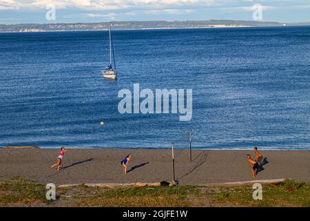 Fort Worden State Park, Post Townsend, Washington State. Spielen von Beachvolleyball und einem Segelboot auf dem Puget Sound. Stockfoto