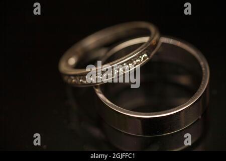 Romantische Eheringe auf dunklem Hintergrund. Hochwertige Fotos Stockfoto