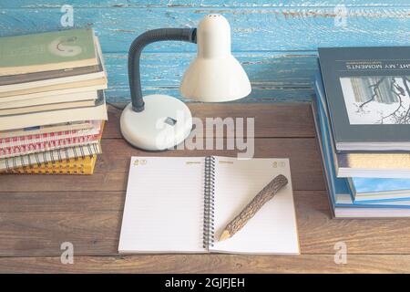 Arbeitsplatz mit Leselampe und Büchern auf altem Holztisch. Vintage-Konzept. Stockfoto