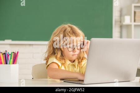 Beschäftigter Teenager Junge im Klassenzimmer. Zurück zur Schule. Wissenstag. Konzept der Online-Bildung. Stockfoto