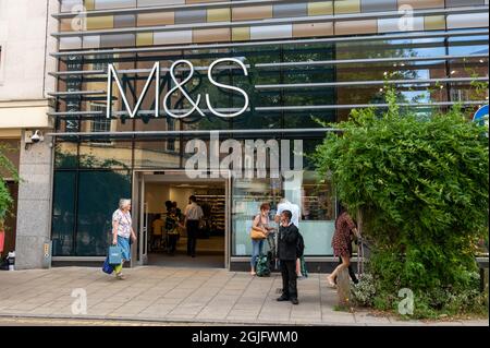 Marks and Spencers Haupteingangsbereich mit Kunden im Haus und Einkäufern, die an einem Sommertag in Norwich vorbeilaufen Stockfoto