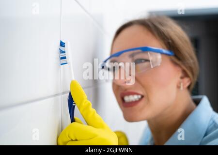 Reinigung Schmutziger Fliesenabstacheln Im Badezimmer Mit Zahnbürste Stockfoto