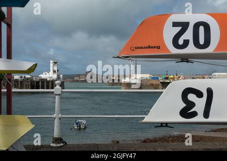 ST HELIER, JERSEY, KANALINSELN - 06. AUGUST 2021: Blick auf den Hafen von Jersey und das Elizabeth Castle durch die Boote des Jersey Rowing Club Stockfoto