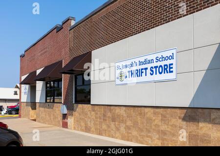 Chamberlain, SD, USA-24 AUGUST 2021:St Joseph's Indian School Thrift Store, an der Main Street Gebäude und Schild. Stockfoto