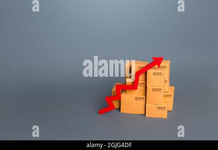 Kisten mit Waren und einem roten Pfeil nach oben. Umsatzwachstum in der Handels- und Transportbranche. Aufstieg der Volkswirtschaft, Handelsbilanz. Industrieprodut Stockfoto