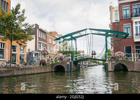 Klassische holländische Stadtszene mit Zugbrücke und Häusern entlang eines Kanals. Stockfoto