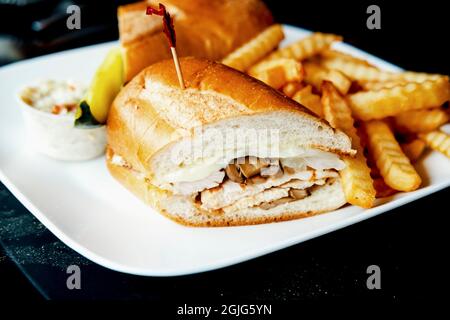 Gegrilltes Hähnchen Philly Cheesesteak mit geschmolzenen Käsepilzen und Pommes frites Stockfoto