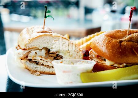Gegrilltes Hähnchen Philly Cheesesteak mit geschmolzenen Käsepilzen und Pommes frites Stockfoto