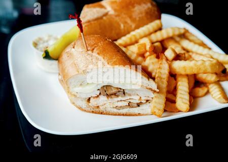 Gegrilltes Hähnchen Philly Cheesesteak mit geschmolzenen Käsepilzen und Pommes frites Stockfoto