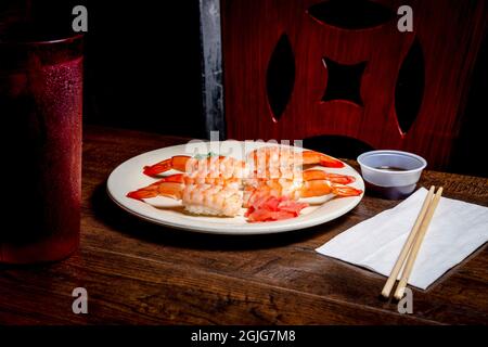 Japanisches Shrimp-Nigiri-Sushi mit Wasabi und eingelegtem Ingwer in dunkler, modischer Beleuchtung Stockfoto
