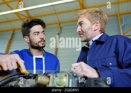 Zwei Mechaniker arbeiten auf ein kleines Flugzeug im Hangar Stockfoto
