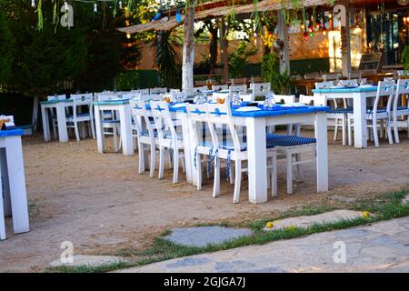 Weiße Holzstühle und -Tische im Garden Summertime in einem Vintage Restaurant Stockfoto