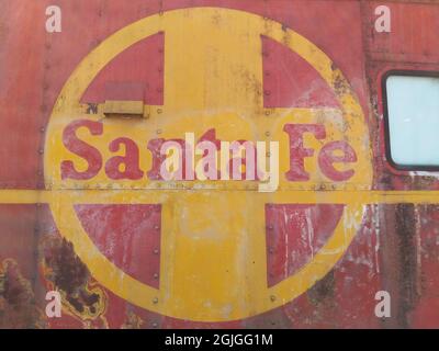 Nahaufnahme des verblichenen Santa Fe Railway Logos auf der Seite des verrosteten Wagens. Stockfoto