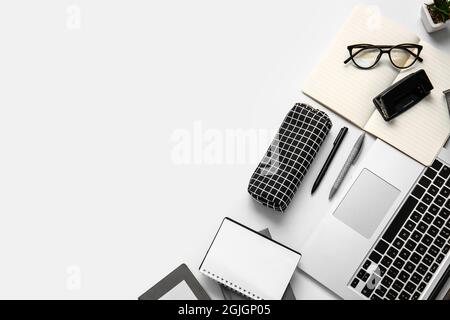 Komposition mit Etui, Briefpapier und Laptop auf weißem Hintergrund Stockfoto