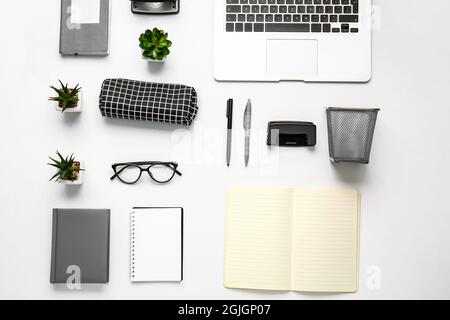 Komposition mit Etui, Schreibwaren und Laptop auf weißem Hintergrund, Nahaufnahme Stockfoto