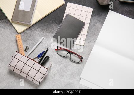 Stilvolles Etui mit Schreibwaren und Brillen auf schwarzem und weißem Hintergrund, Nahaufnahme Stockfoto