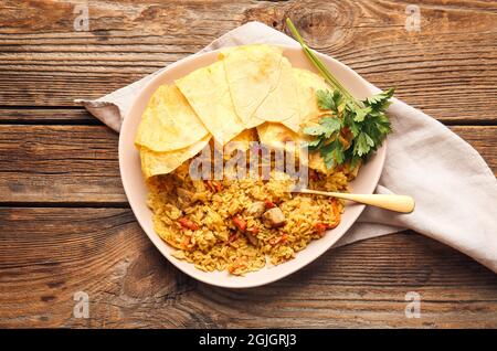 Teller mit schmackhaftem Shah Pilaf auf Holzhintergrund Stockfoto