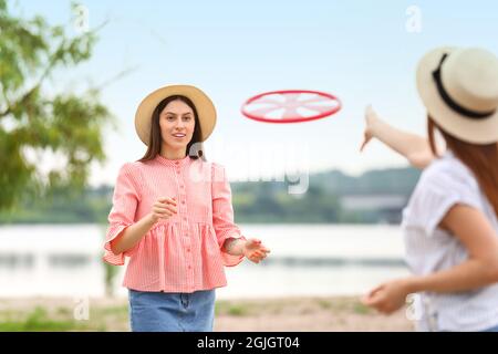 Schöne junge Frauen spielen Frisbee im Freien Stockfoto