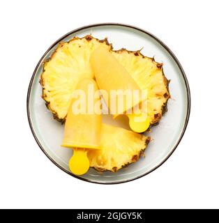 Teller mit leckeren Ananaspopsicles auf weißem Hintergrund Stockfoto