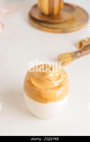 Ein Glas leckeren dalgona hojicha Latte auf hellem Hintergrund Stockfoto