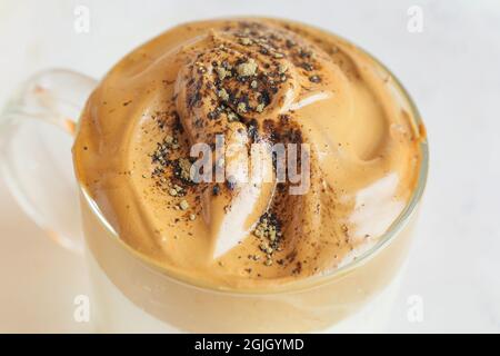 Glas Tasse schmackhaften dalgona hojicha Latte auf hellem Hintergrund, Nahaufnahme Stockfoto