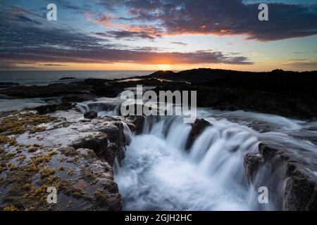 Wellenflut fließt von einer Lavagesteinküste bei Sonnenuntergang, Keahole, North Kona, Hawaii Island ( The Big Island ), Hawaii, USA ( Central Pacific Ocean Stockfoto
