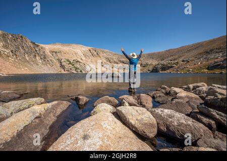 Abenteuerlicher Wanderer steht auf einem kleinen Felsen am Ptarmigan Lake, einem abgelegenen, weniger besuchten Bergsee im Rocky Mountain National Park Colorado, USA Stockfoto