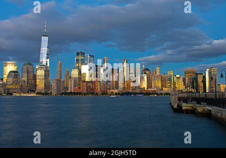 Am späten Abend und bei Nacht Blick auf das Finanzviertel von Lower Manhattan vom Liberty State Park an einem teilweise bewölkten Tag -03 Stockfoto