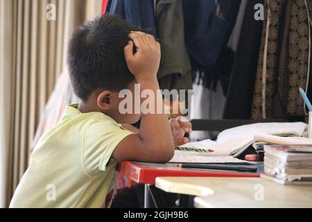 15. Juli 2019, Savar, Dhaka, Bangladesch. Das Kind macht Schulaufgaben und denkt über das Lernen nach Stockfoto