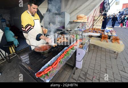 Ein Marokkaner, der Fleisch und traditionelle marokkanische Wurst in einem kleinen Restaurant in der Medina von Salé, Marokko, gegrillt. Stockfoto