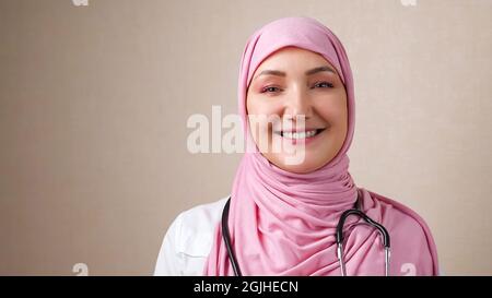 Ärztin in Hijab mit Phonendoskop am Hals lächelnd und Blick auf die Kamera Stockfoto