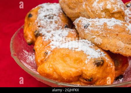 Traditionelle holländische Silvestersnacks in einer Glasschale auf einer roten Tischdecke Stockfoto