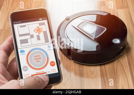 Automatischer Roboter-Staubsauger drahtlose Verbindung mit Smartphone-Anwendung zu steuern und zu überwachen Arbeitsanzeige auf Handy-Bildschirm für moderne e Stockfoto