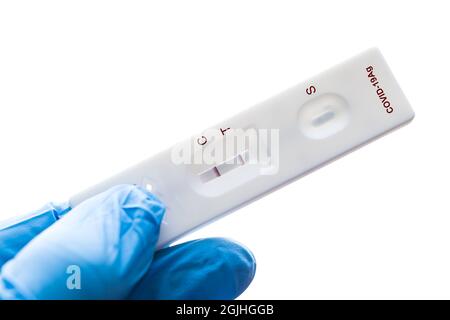 Der getestete Covid-19 Antigen Test Kit (ATK) zeigt ein Coronavirus-infiziertes positives Streifenband an der Testlinie isoliert auf weißem Hintergrund. Stockfoto