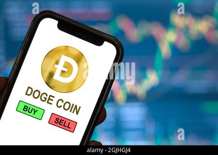 Dogecoin Bit Münzhandel Ansicht kaufen oder verkaufen auf Smartphone mit Unschärfe Kryptowährung Markt steigenden Preis Bildschirm Hintergrund. Stockfoto