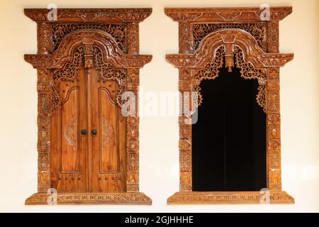 Das Muster der Schnitzerei Wayang Gunungan an der Tür eines indonesischen Holzhauses, mit einem künstlerischen und stilvollen traditionellen ethnischen Feeling. Stockfoto