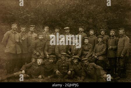 Gruppe von 1914-18 Soldaten der kaiserlichen Deutschen Armee aus dem Ersten Weltkrieg posieren mit ihrem Offizier (mittlere Reihe, Spitzmütze) für ein Porträt. Die 21 Infanteristen tragen geknöpfte Tuniken und Futtermützen, wobei viele Zigaretten in der Hand haben. Die Zahl „118“ ist auf einigen Schulterbrettern der Männer sichtbar, was bedeutet, dass sie zum Infanterie-Regiment 118 (Infanterie-Regiment Prinz Carl Nr. 118) gehörten; Teil der 56. Infanteriedivision, die von 1915 bis 1918 schwere Verluste erlitten hat, die an der östlichen und westlichen Front in Kämpfen wie Verdun, der Somme und Arras ausgetragen wurden. Stockfoto