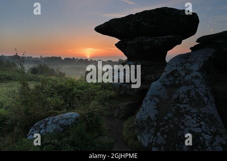 Die Sonne geht über einer Felsformation auf, die als „The Anvil“, Brimham Rocks, Nidderdale, North Yorkshire, Großbritannien, bekannt ist Stockfoto