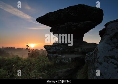 Die Sonne geht über einer Felsformation auf, die als „The Anvil“, Brimham Rocks, Nidderdale, North Yorkshire, Großbritannien, bekannt ist Stockfoto