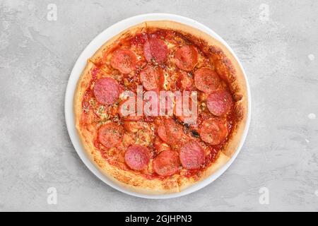 Blick von oben auf die kleine Pizza Pepperoni auf einem Teller Stockfoto