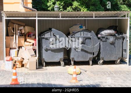 Karton wird zu Ballen gebündelt. Mülltonnen voll mit Müll. Müll ist eine Müllhalde. Mülltonnen in der Stadt. Stockfoto