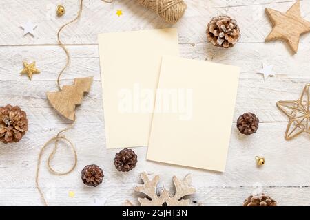 Winter Weihnachten Komposition mit Karten flach legen. Weihnachts- und Neujahrsgrußkartenvorlage mit Tannenzapfen, Holzdekorationen und Seil auf Marb Stockfoto