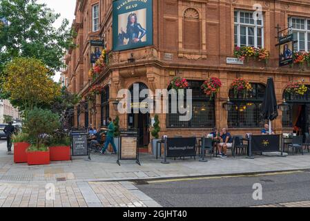 Menschen sitzen und essen an Tischen vor dem Marlborough Head Pub in der North Audley Street, Mayfair, London, England, Großbritannien Stockfoto
