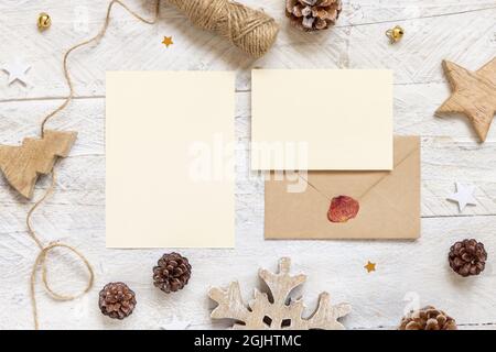 Winter Weihnachten Komposition mit Karten und versiegeltem Umschlag flach legen. Weihnachten und Neujahr Grußkarten Vorlage mit Tannenzapfen, Holzdekor Stockfoto