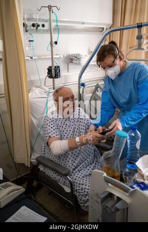 Die Covid-19-Einheit des Liege-Krankenhauses, die sich um eine alte Person kümmert. Lüttich, Belgien. Stockfoto