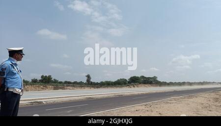 Barmer, Indien. September 2021. Ein Sicherheitsmann wacht während der Landung eines Flugzeugs der indischen Luftwaffe Jaguar während der Einweihung der Notlandeeinrichtung im Abschnitt Gandhav Bhakasar auf dem National Highway NH-925 im Barmer Bezirk in der Nähe der Grenze zwischen Indien und Pakistan. Verteidigungsminister Rajnath Singh, Straßenverkehrsminister Nitin Gadkari und Luftwaffenchef RKS Bhadauria weihten den Streifen ein, der von der National Highways Authority of India (NHai) in enger Abstimmung mit der indischen Luftwaffe (IAF) errichtet wurde. (Foto: Sumit Saleswat/Pacific Press) Quelle: Pacific Press Media Production Corp./Alamy Live News Stockfoto