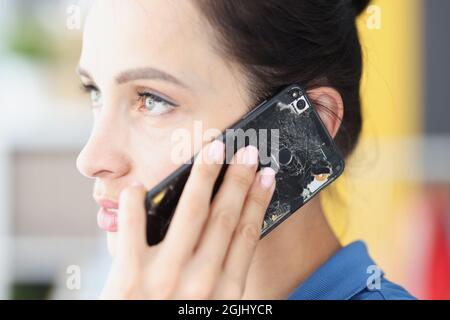 Frau spricht auf gebrochenem schwarzen Smartphone Nahaufnahme Stockfoto